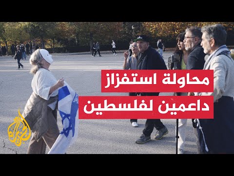 شاهد | سيدة ترتدي قناعا وتلوح بعلم إسرائيل أمام داعمين لغزة في مدريد